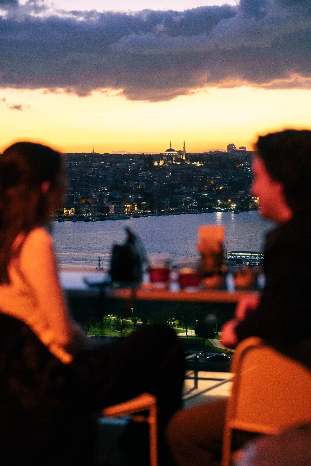 Guests on the terrace as the city lights come on