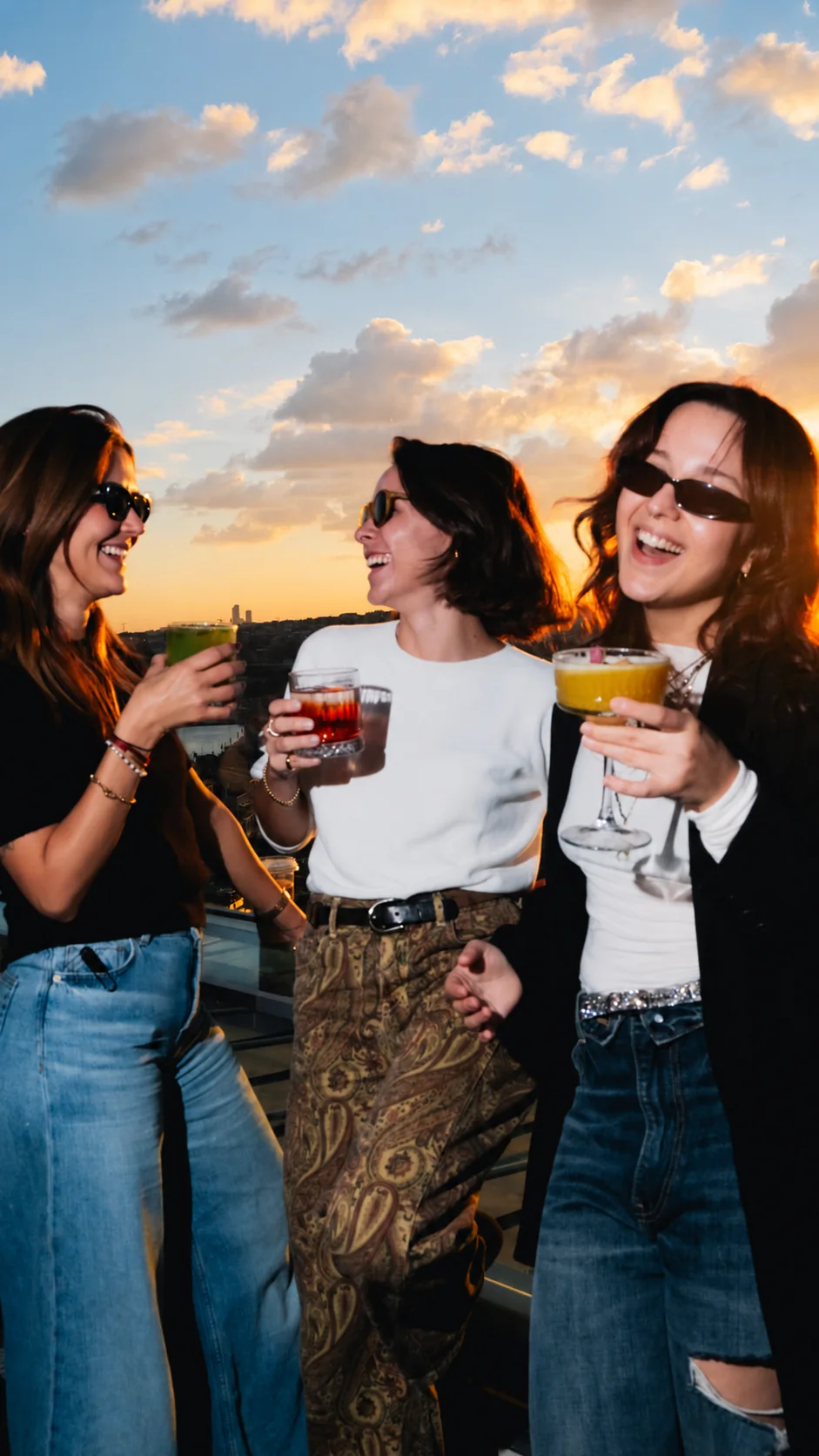 Three friends sharing a moment on the terrace at sunset