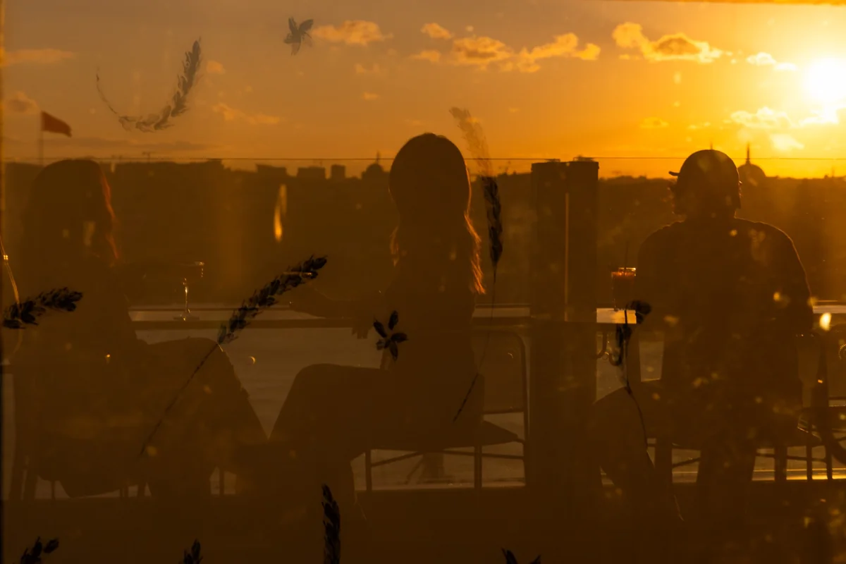 Guests reflected in glass against the golden Istanbul skyline