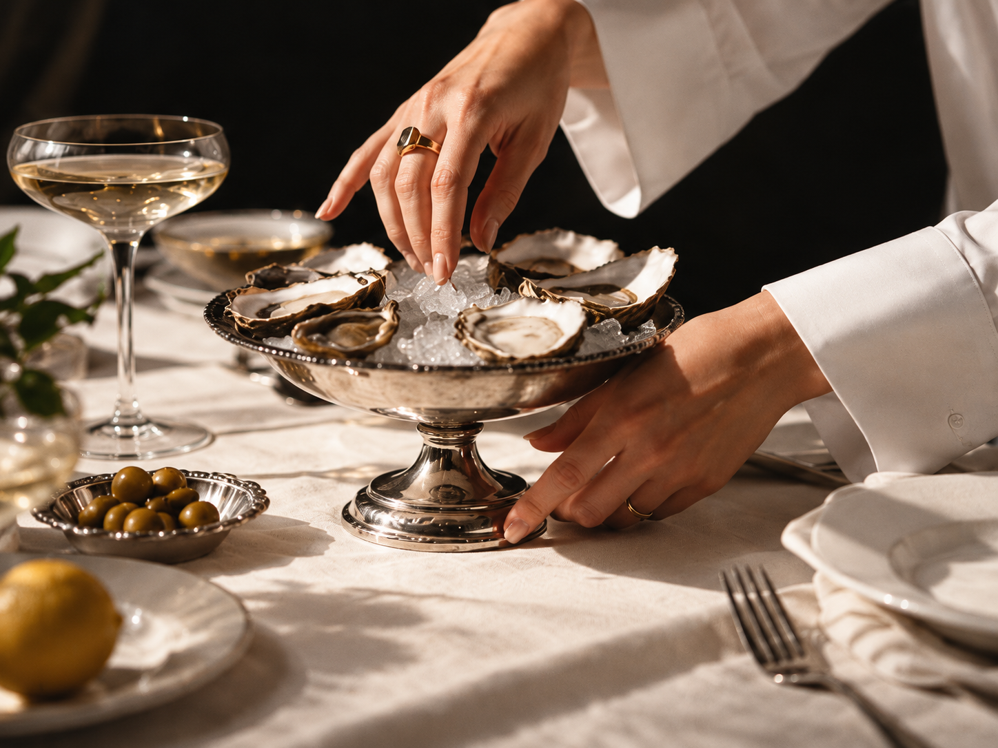 Illustrative campaign: an oyster platter and champagne on a linen table